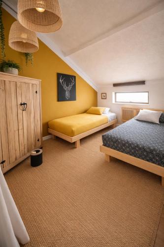 a bedroom with two beds and a yellow wall at SURF HOSTEL BIARRITZ in Biarritz