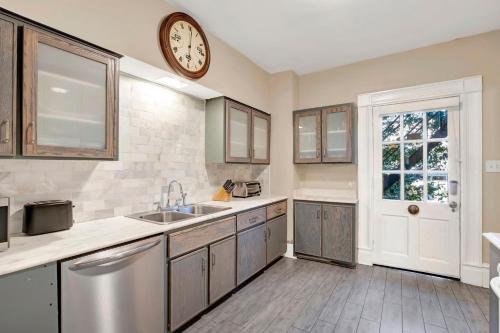 a kitchen with a sink and a clock on the wall at Oglethorpe Estate in Savannah