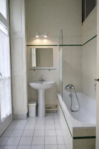 a bathroom with a sink and a bath tub and a sink at L'intemporel, gîte de charme pour 4 à 5 personnes in Saint-Gervais-la-Forêt
