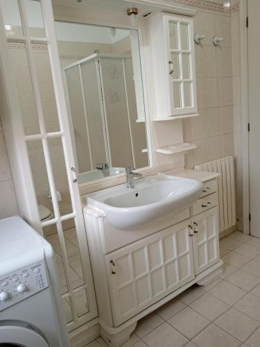 a white bathroom with a sink and a mirror at Colibrì in Bordighera