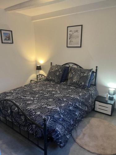 a bedroom with a bed with a blue comforter at Gîte au Petit Café in Châteauvillain