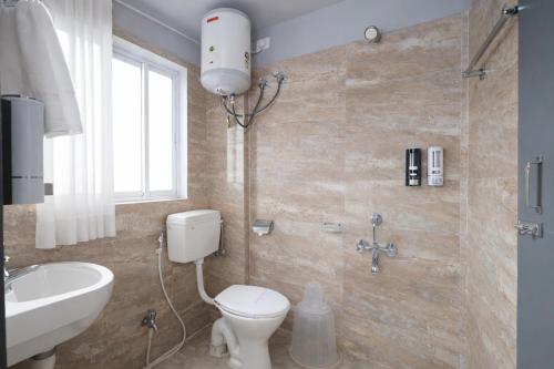 a bathroom with a toilet and a sink at RJB Grand in Guwahati