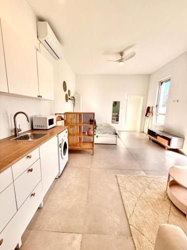 a kitchen with a sink and a stove top oven at Flamingo Suite in Atlit