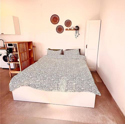 a bedroom with a bed with a black and white comforter at Flamingo Suite in Atlit