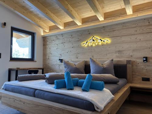 a bedroom with a large bed with blue pillows at NEUBAU Alpinstar Chalet - Luxus, Bergblick, Loipe, Sauna in Leutasch