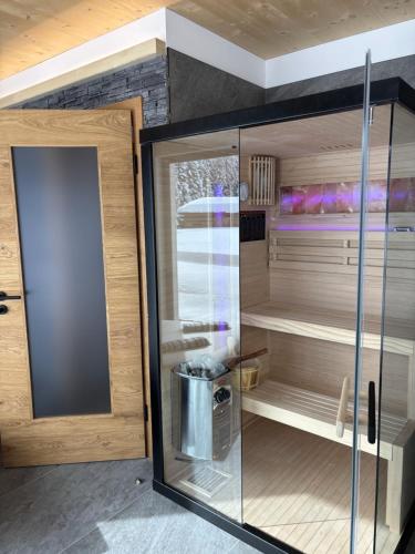 a cupboard with a glass door in a room at NEUBAU Alpinstar Chalet - Luxus, Bergblick, Loipe, Sauna in Leutasch