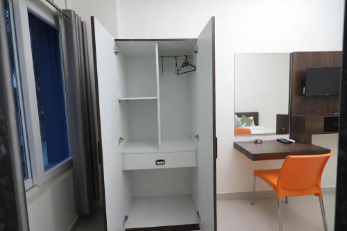 a room with a desk and a chair and a window at Orchid Palace in Gauhāti