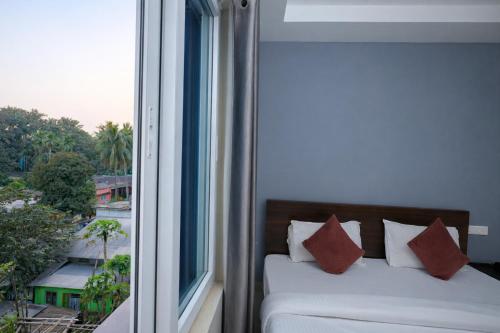 a bedroom with a bed and a large window at Orchid Palace in Gauhāti