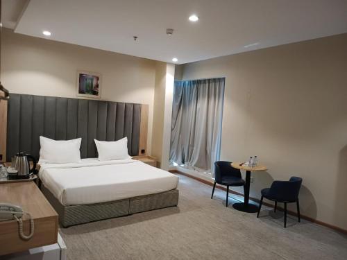 a hotel room with a bed and a table and chairs at شقق الريم الجديد للشقق المخدومة Al Reem Al Jadid residence in Yanbu