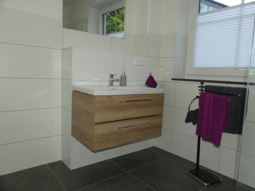 a white bathroom with a sink and a window at Marktperle in Sagard