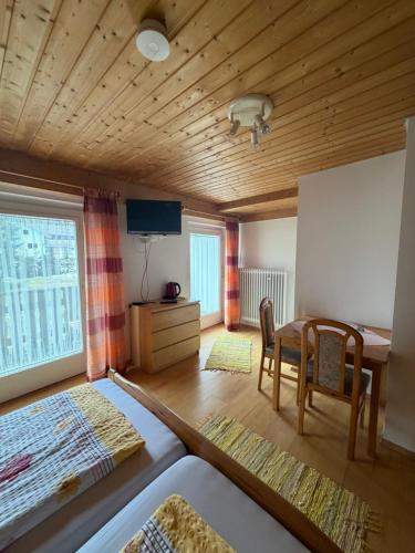 a room with a bed and a table and a desk at Pension Silberdistel in Ühlingen-Birkendorf