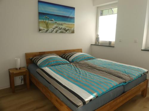 a bed in a bedroom with a painting on the wall at Marktperle in Sagard