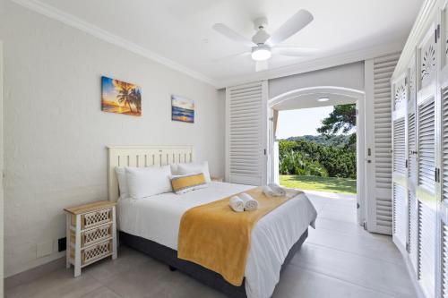 a bedroom with a bed and a large window at 9 Montego Bay Caribbean Estates in Port Edward