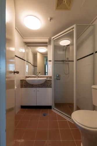 a bathroom with a shower and a sink and a toilet at Lakefront Panorama – Sky Collection Suite in Canberra