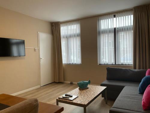 a living room with a couch and a table at Fisherman's House by Hofstad Hotels in Scheveningen