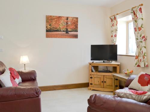 a living room with two couches and a flat screen tv at The Dairy - Op3 in Carmarthen