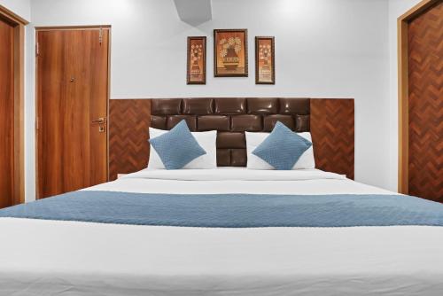 a bedroom with a large bed with blue pillows at Hotel Dream Inn Thane in Thane