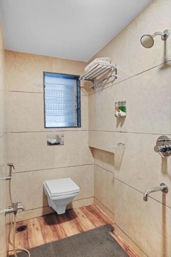 a bathroom with a toilet and a window at Hotel Dream Inn Thane in Thane