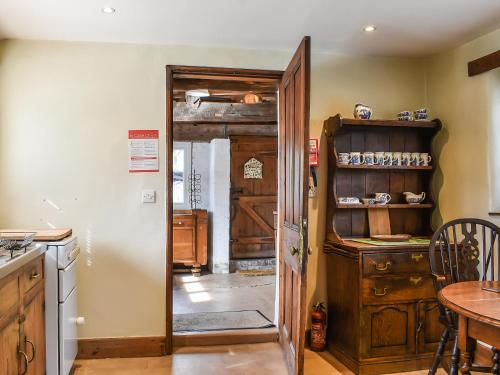 a kitchen with a door open to a kitchen with a table at Stable Cottage in Windermere