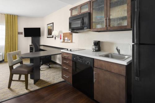 a kitchen with a sink and a desk in a room at Candlewood Suites Norfolk Airport by IHG in Norfolk