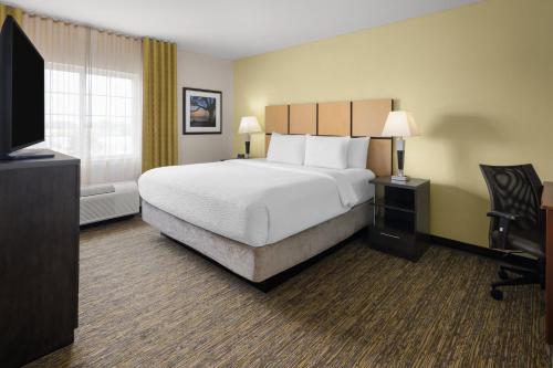 a hotel room with a bed and a television at Candlewood Suites Norfolk Airport by IHG in Norfolk