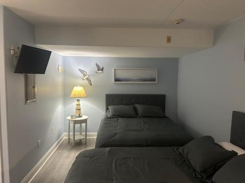 a bedroom with two beds and a table with a lamp at Sunbeach Condo 900 Wesley Avenue Unit 109 in Ocean City