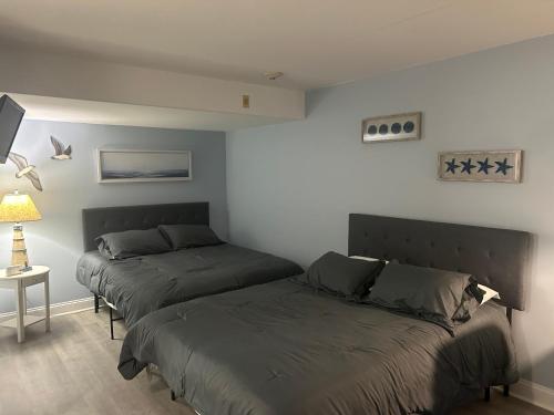 a bedroom with two beds and a table with a lamp at Sunbeach Condo 900 Wesley Avenue Unit 109 in Ocean City