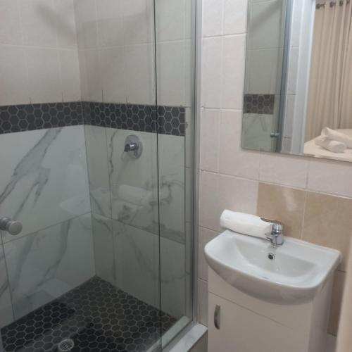 a bathroom with a shower and a toilet and a sink at Comfort Retreat in Roodepoort