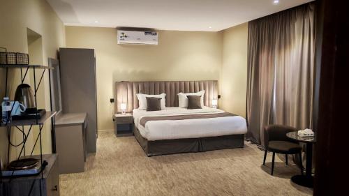 ein Hotelzimmer mit einem großen Bett und einem Stuhl in der Unterkunft فخامة العزيزية in Al-'Ula
