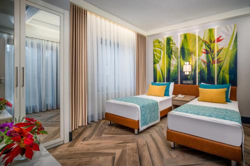 a hotel room with two beds and a painting on the wall at Baia Salima Kemer in Kemer