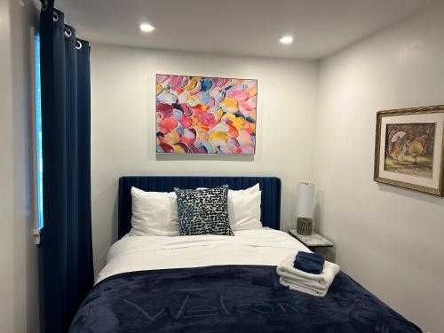 a bedroom with a bed with a painting on the wall at Serenity Charm - Walk in Town, Shaw, Hottub in Niagara-on-the-Lake