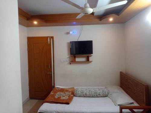 a room with a bed and a flat screen tv on the wall at Hotel Sikder-02 Residential in Dhaka