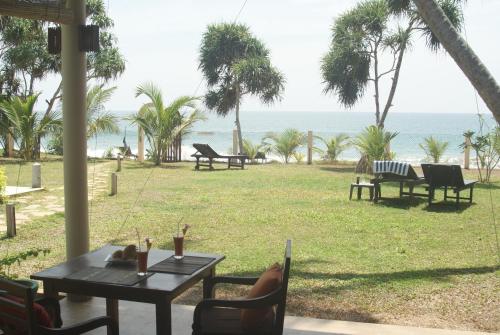a table and chairs with a view of the ocean at Lanka Beach Boutique Bungalows & Grand Villa in Tangalle