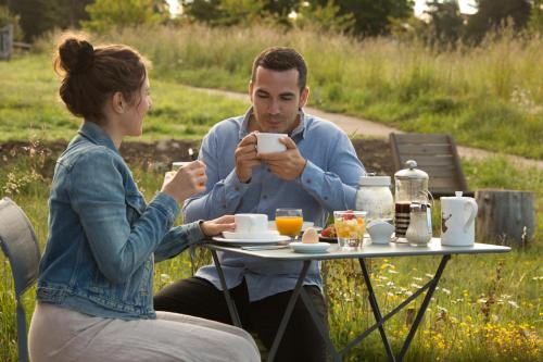 a man and woman sitting at a table looking at their cell phones at instants d'Absolu Ecolodge & Spa in La Boissonnière