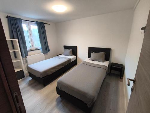a room with two beds and a window at The Eau Rouge 600m from the entrance of the circuit in Stavelot