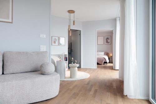 a living room with a couch and a bedroom at Laya Living Lucerne - Kriens in Lucerne