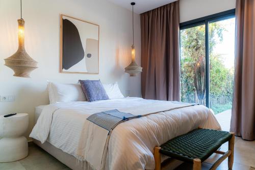 a bedroom with a large bed and a window at Maison soli Marrakech in Bou Khaoua