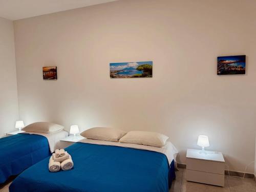 two beds in a bedroom with blue sheets at B&B Torrebianca in Aversa