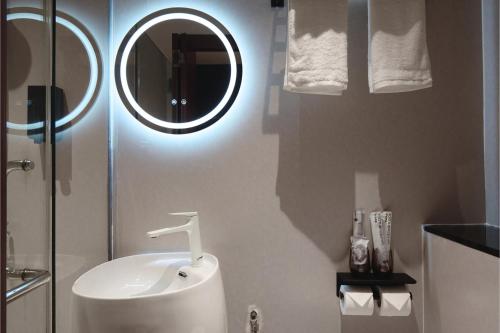 a bathroom with a sink and a mirror at Asphodel Inn - Newly Renovated in Singapore