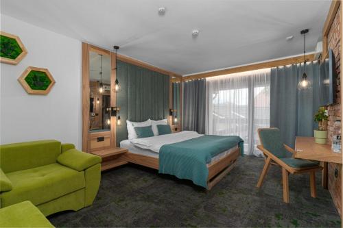 a hotel room with a bed and a green couch at Forest Green & Spa in Gura Humorului