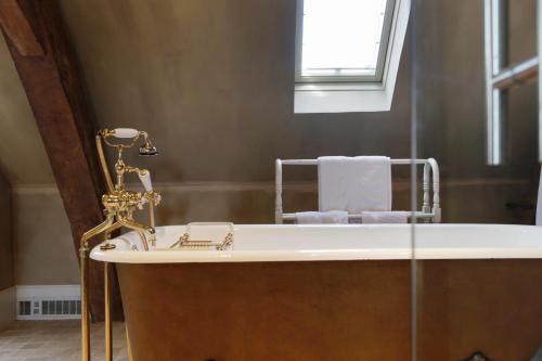 a bath tub in a bathroom with a window at Hotel Recour in Poperinge