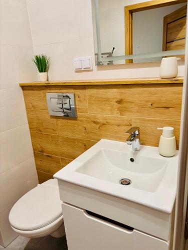 a bathroom with a white sink and a toilet at Lux Corner Park przestronne mieszkanie z klimatyzacją, balkonem i podziemnym garażem in Pruszków