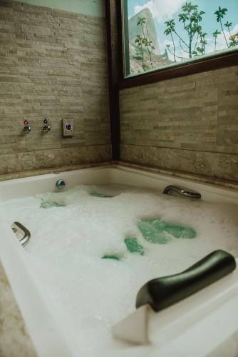a bath tub filled with water in front of a window at Pousada Peterle in Domingos Martins