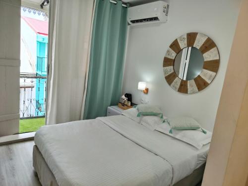 ein Schlafzimmer mit einem Bett und einem Spiegel an der Wand in der Unterkunft Down Town Cozy in Pointe-à-Pitre