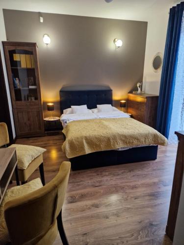 a bedroom with a bed and a table and chairs at Granatowy odpoczynek - wieś Pogórze dla zmotoryzowanych in Pogórze