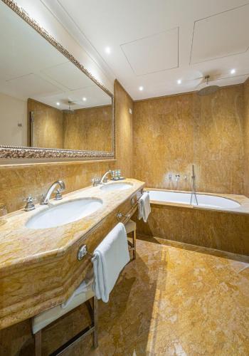 a large bathroom with two sinks and a tub at Hotel Villa Barbarich in Mestre