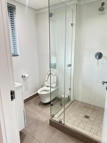 a bathroom with a toilet and a glass shower at Pebble Beach Sibaya 146 in Sibaya