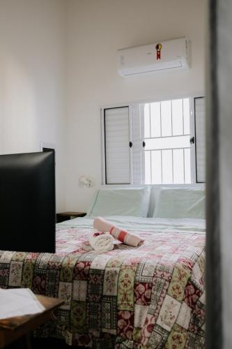 a bedroom with a bed with a quilt on it at Joia do Pepira in Brotas