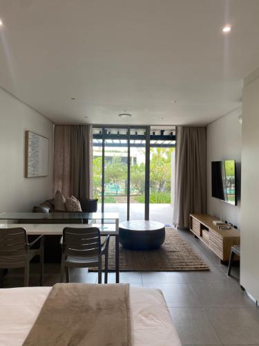a living room with a table and a couch at Pebble Beach Sibaya 146 in Sibaya