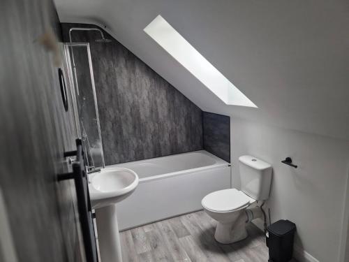 a bathroom with a white toilet and a sink at Brigg new build home in Brigg